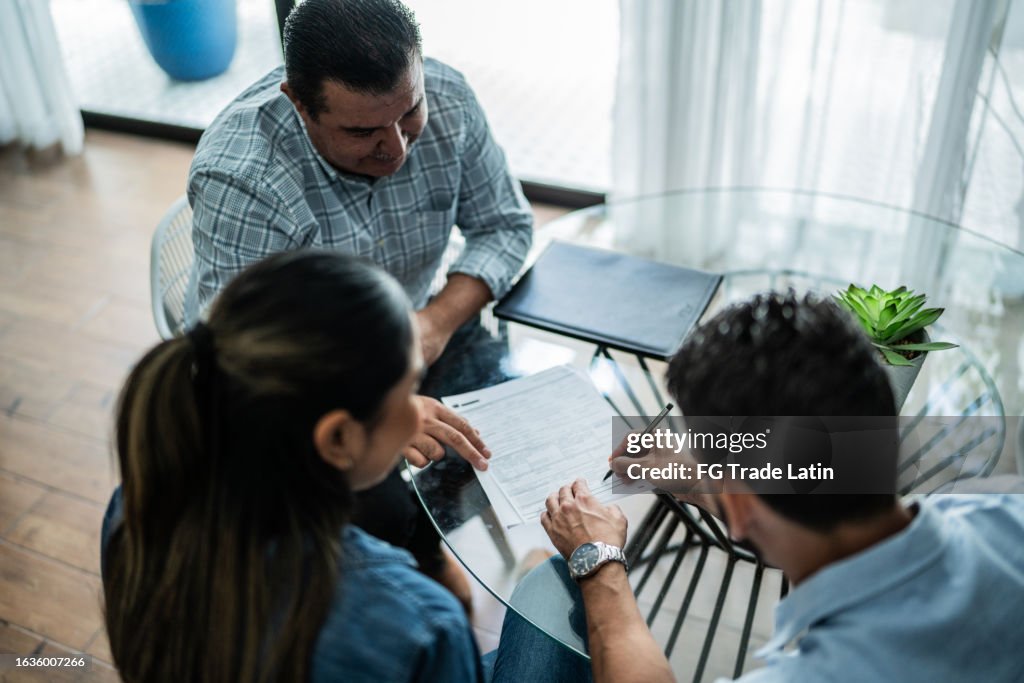 Clientes firmando contrato en una casa