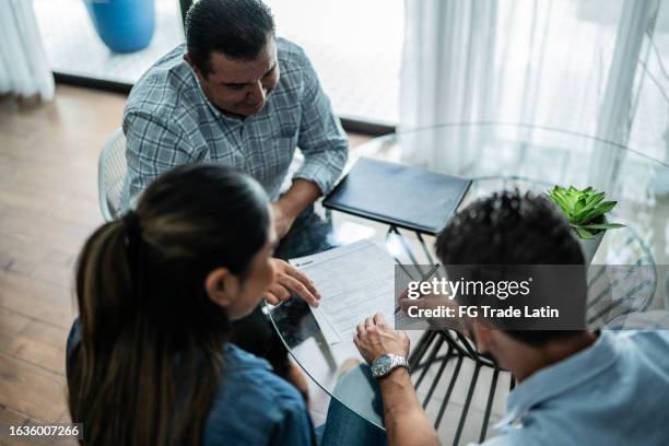 clients signant un contrat dans une maison - mortgage loan photos et images de collection