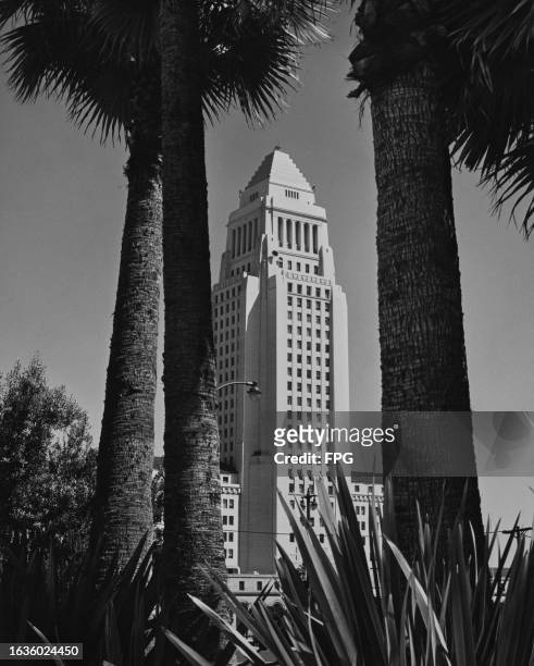 Los Angeles City Hall, framed by the trunks of palm trees, in Los Angeles, California, June 1962. Designed by architects John Parkinson, John C...