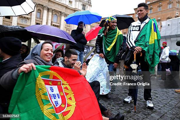 Supporters of the Brazilian Cardinal Odilo Pedro Scherer gather under umbrellas in St Peter's Square as they wait for news on the election of a new...