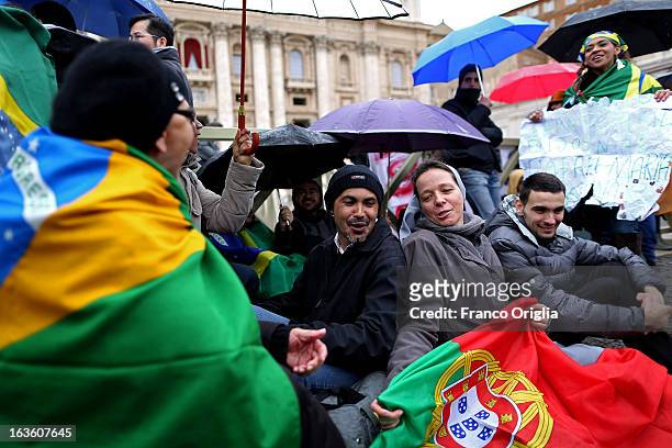 Supporters of the Brazilian Cardinal Odilo Pedro Scherer gather under umbrellas in St Peter's Square as they wait for news on the election of a new...