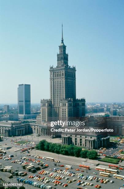 Aerial view of cars and coaches parked in front of the Palace of Culture and Science high-rise building in central Warsaw, capital of Poland in 1989....