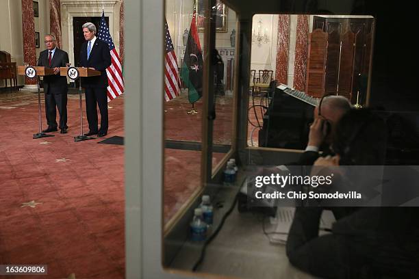 Translators work in a sound-proof booth as Libyan Prime Minister Ali Zeidan and U.S. Secretary of State John Kerry hold a news conference in between...