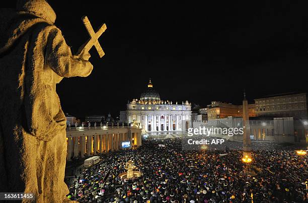General view shows the crowd on St Peter's square as white smoke rises from the chimney on the roof of the Sistine Chapel meaning that cardinals...