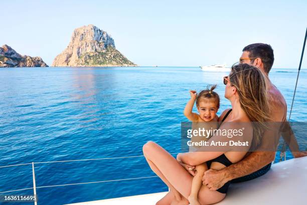 family with baby girl enjoying vacations sailing on catamaran deck in ibiza island. - es vedra stock pictures, royalty-free photos & images