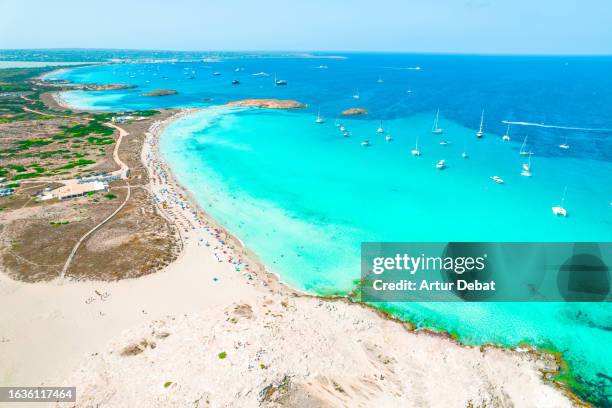 aerial view by drone above the paradise island of formentera in spain with the ses illetes crowded beach in summer. - insel formentera stock-fotos und bilder