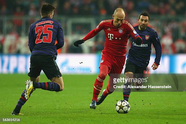 Arjen Robben of Muenchen battles for the ball with Carl Jenkins of Arsenal and his team mate Santi Cazorla during the UEFA Champions League Round of...