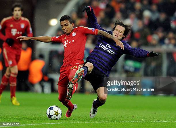 Tomas Rosicky of Arsenal challenges Luiz Gustavo of Bayern Munich during the UEFA Champions League Round of 16 second leg match between Bayern...