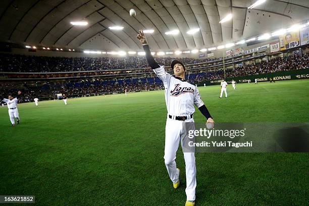 Kenta Maeda of Team Japan tosses an autographed ball into the stands during Pool 1, Game 6 between the Netherlands and Japan in the second round of...