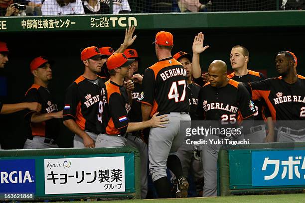 David Bergman is greeted by teammates after being relieved in the bottom of second inning during Pool 1, Game 6 between the Netherlands and Japan in...