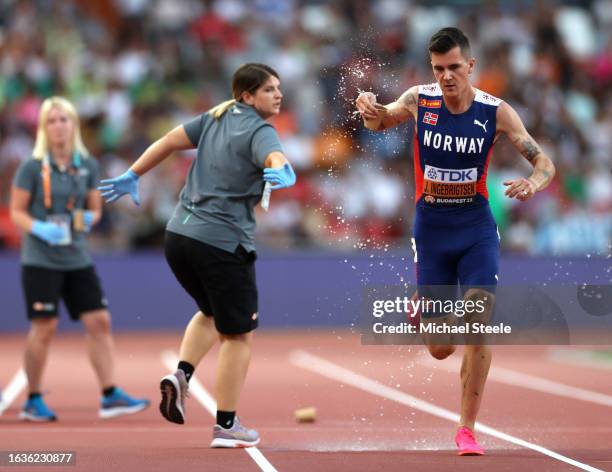 Jakob Ingebrigtsen of Team Norway takes a cup of water as he competes in the Men's 5000m Heats during day six of the World Athletics Championships...