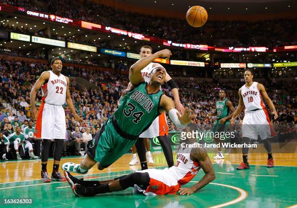 Paul Pierce of the Boston Celtics loses the ball after colliding with Amir Johnson of the Toronto Raptors during the game on March 13, 2013 at TD...