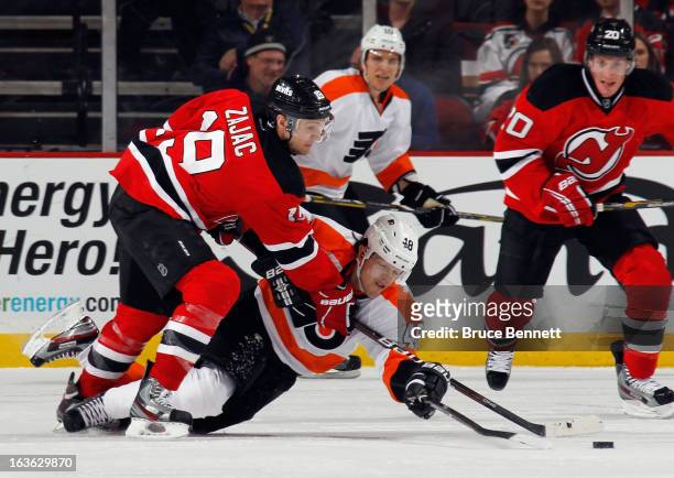 Travis Zajac of the New Jersey Devils and Danny Briere of the Philadelphia Flyers battle for the puck at the Prudential Center on March 13, 2013 in...