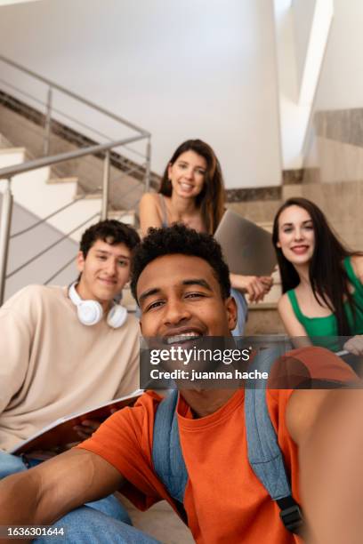 group of students taking a selfie together and smiling on the stairs in a break - gruppe oder gruppenspiel stock-fotos und bilder