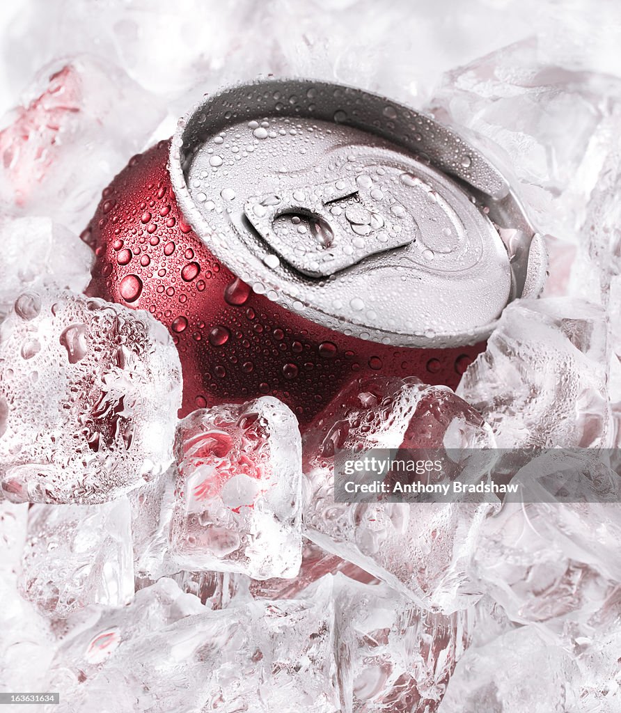 Red can of drink buried in ice