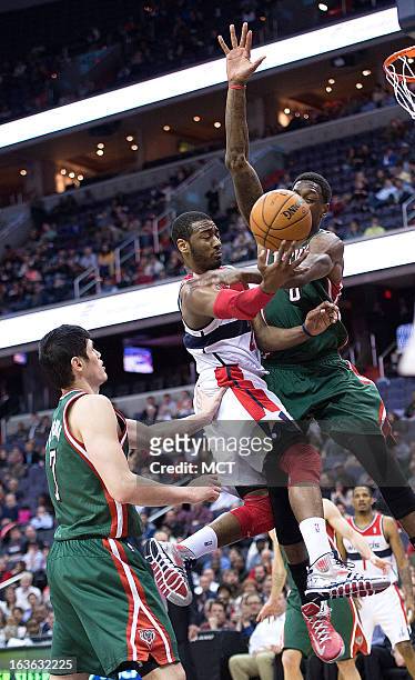 Washington Wizards point guard John Wall scores against Milwaukee Bucks center Larry Sanders as Bucks small forward Ersan Ilyasova trails on the play...