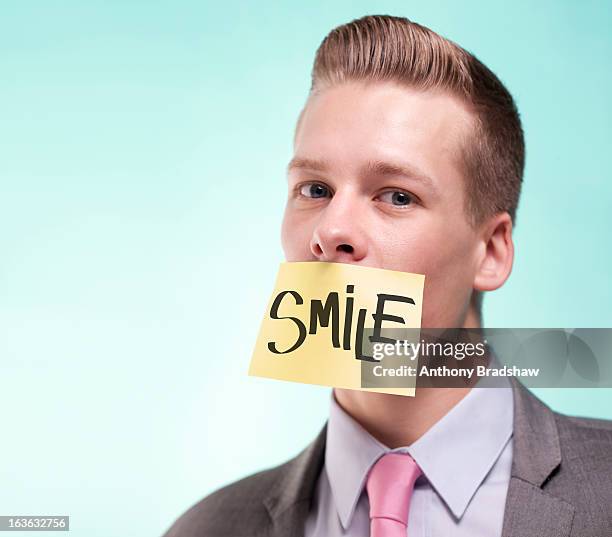 businessman with a painted smile - fake smile ストックフォトと画像