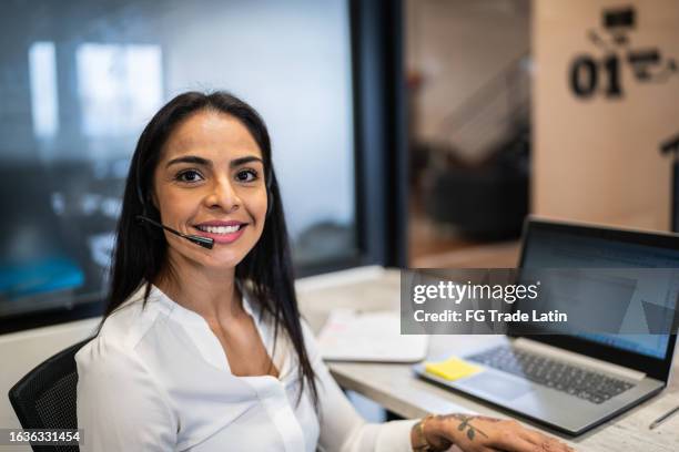 portrait of a mid adult woman working using laptop at office - latin beauty stockfoto's en -beelden