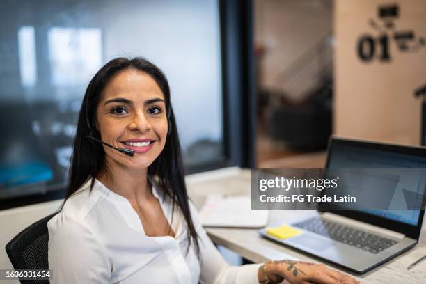 portrait of a mid adult woman working using laptop at office - beautiful latin women stock pictures, royalty-free photos & images