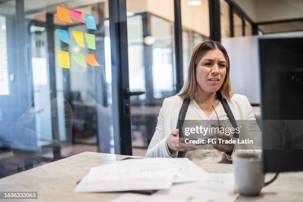 besorgte junge geschäftsfrau, die im büro arbeitet - trockene augen stock-fotos und bilder