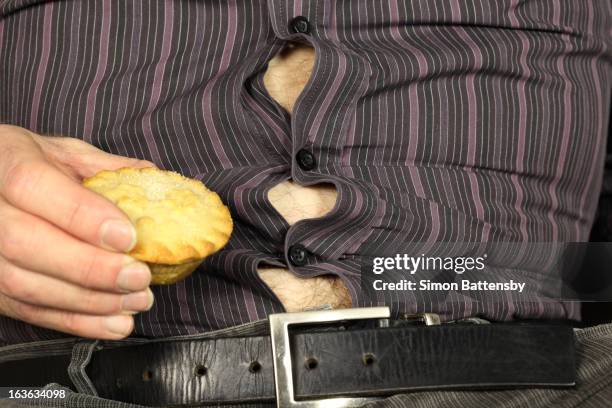 bulging stomach stretches shirt - shirt buttons popping stock pictures, royalty-free photos & images