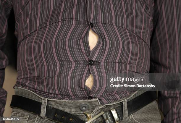bulging stomach stretches shirt - shirt buttons popping stock pictures, royalty-free photos & images