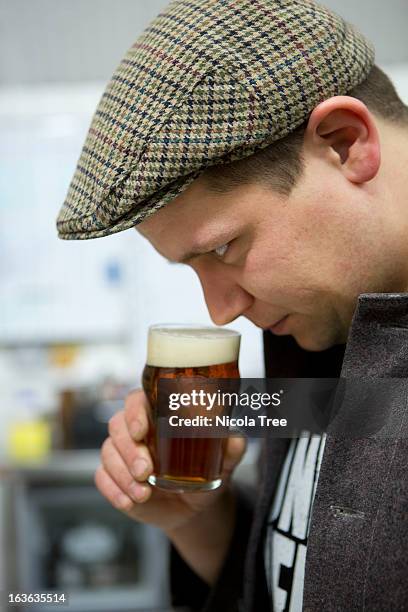 a brewery technician smelling and tasting beer. - nicola beer fotografías e imágenes de stock