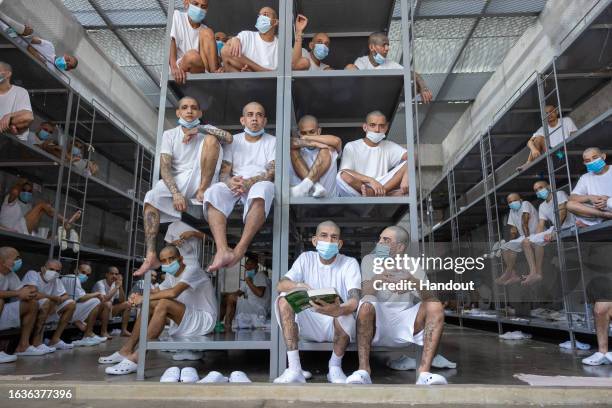 In this handout picture provided by the Salvadoran presidency Inmates remain at their cell during a humanitarian visit to counter-terrorism...