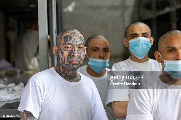 In this handout picture provided by the Salvadoran presidency Inmates remain at their cell during a humanitarian visit to counter-terrorism...