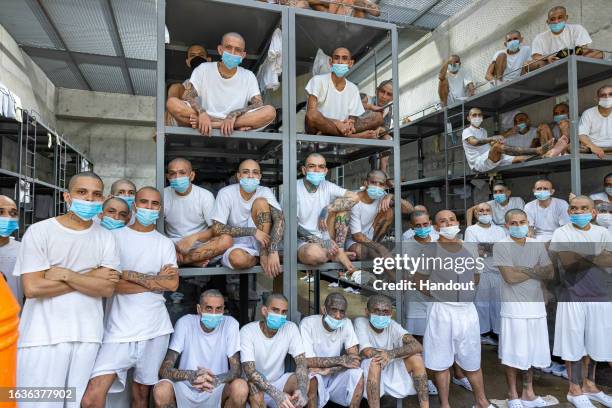 In this handout picture provided by the Salvadoran presidency Inmates remain at their cell during a humanitarian visit to counter-terrorism...