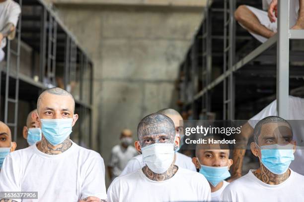 In this handout picture provided by the Salvadoran presidency Inmates remain at their cell during a humanitarian visit to counter-terrorism...