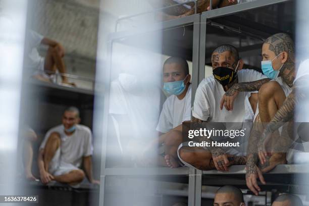 In this handout picture provided by the Salvadoran presidency Inmates remain at their cell during a humanitarian visit to counter-terrorism...