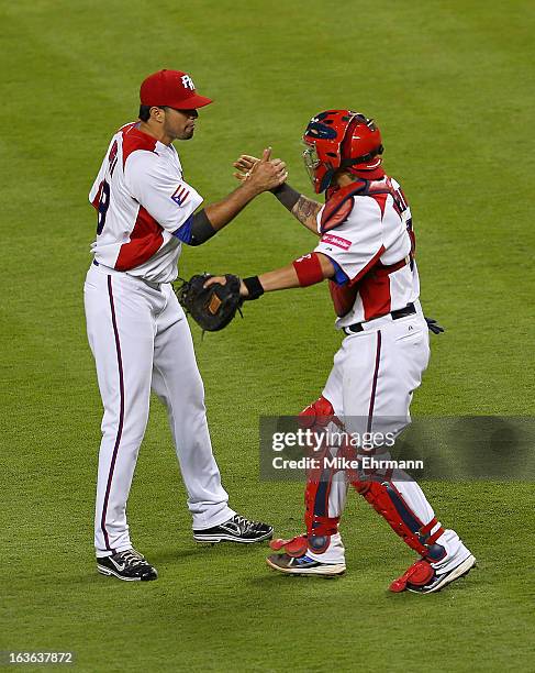 Fernando Cabrera and Yadier Molina of Puerto Rico celebrates after winning a World Baseball Classic second round game against Italy at Marlins Park...
