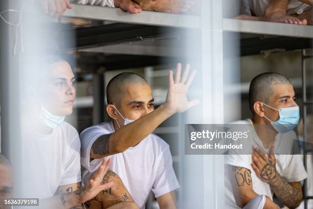 In this handout picture provided by the Salvadoran presidency Inmates remain at their cell during a humanitarian visit to counter-terrorism...