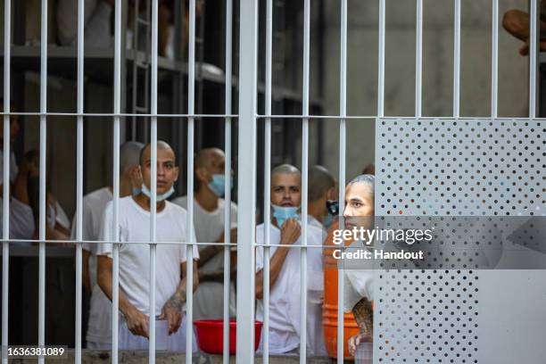 In this handout picture provided by the Salvadoran presidency Inmates remain at their cell during a humanitarian visit to counter-terrorism...