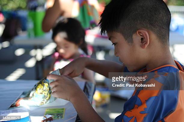 boy opening goodie bag at birthday pool party - goodie bag stock pictures, royalty-free photos & images