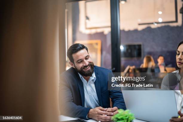 mature businessman talking to coworker on a meeting at office - meeting candid office suit stock pictures, royalty-free photos & images