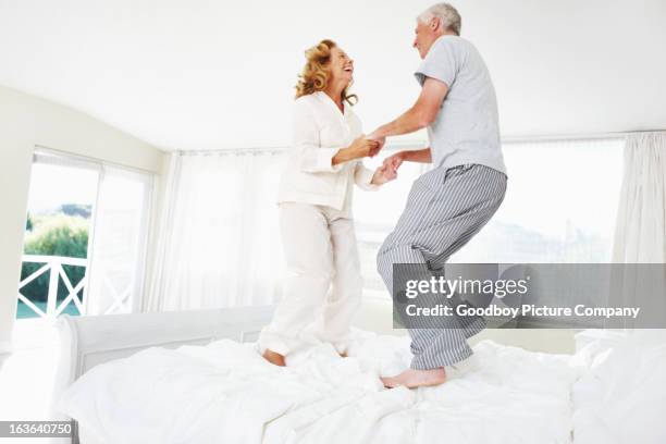 genießen ihren ruhestand in vollen zügen - old couple jumping stock-fotos und bilder