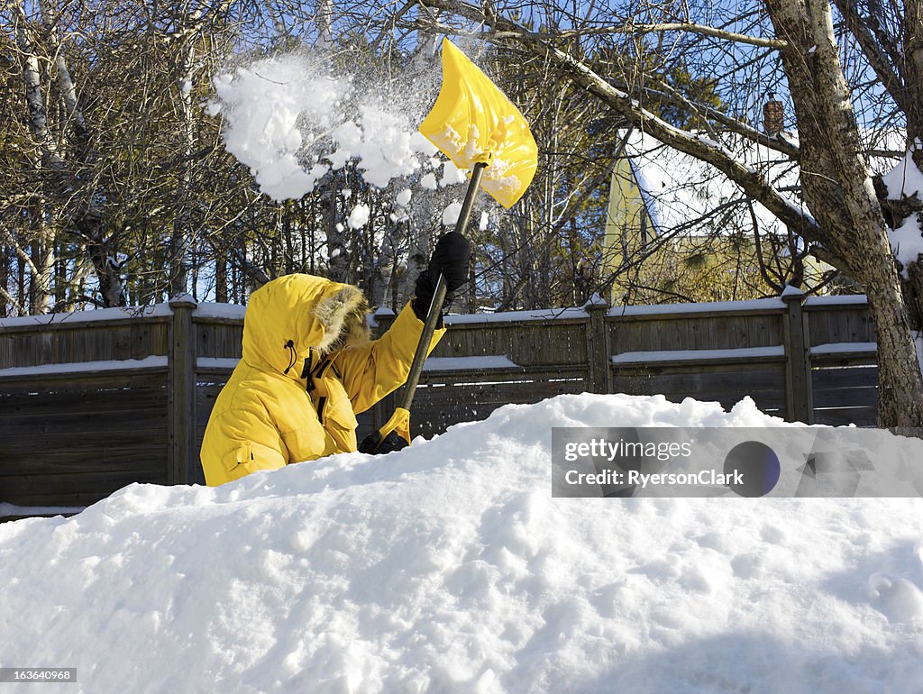 Homem Shovelling Após uma tempestade de neve.