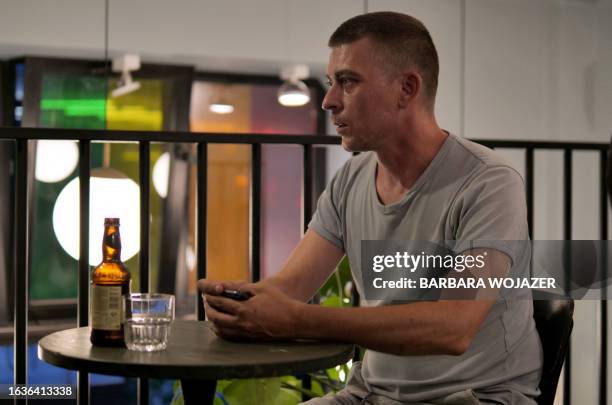 Yevgen Kuruch, 38-years-old Ukrainian reserve officer and now taxi driver, sits in a café in Warsaw, Poland, on July 31, 2023. The war of Russia...