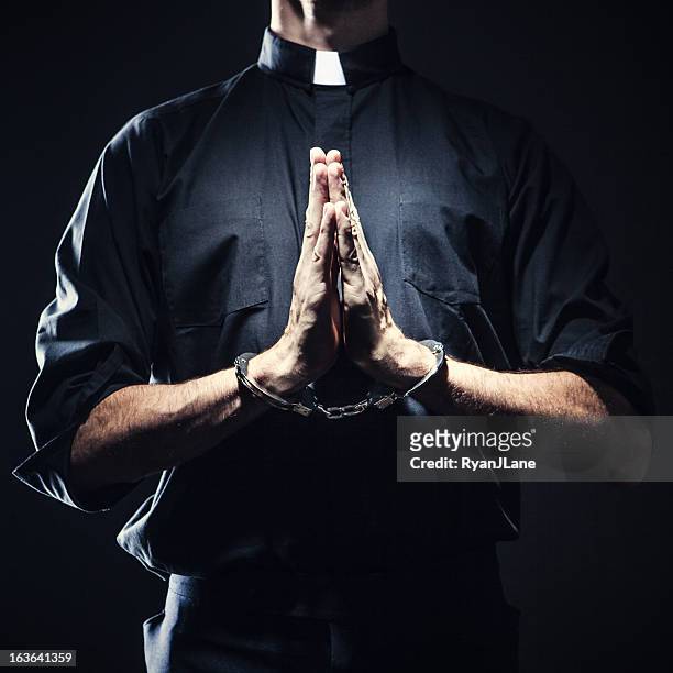 padre católico rezar em algema - handcuffs imagens e fotografias de stock