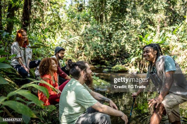 tourist guide explaining to a group of friends during hiking in the forest - brazil rainforest stock pictures, royalty-free photos & images