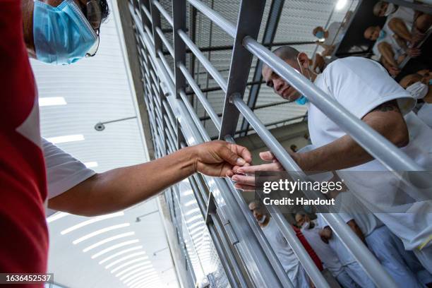 In this handout picture provided by the Salvadoran presidency An inmate receives medicine during a humanitarian visit to counter-terrorism...