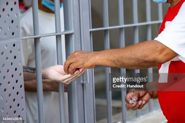 In this handout picture provided by the Salvadoran presidency An inmate receives medicine during a humanitarian visit to counter-terrorism...
