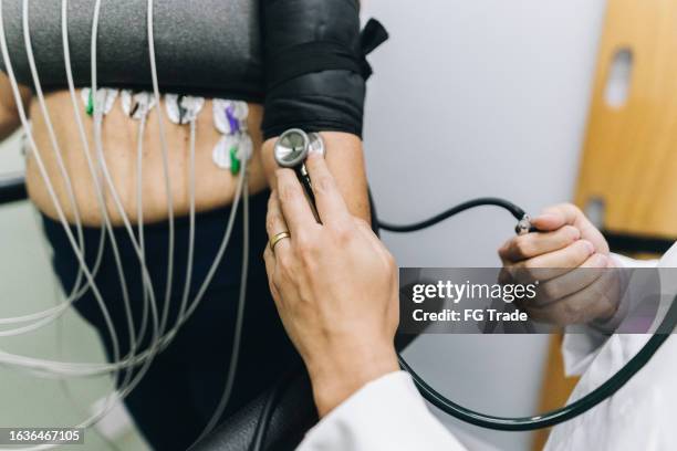 nahaufnahme einer menschlichen hände, die einen patienten in einem krankenhaus untersucht - belastungsprobe stock-fotos und bilder