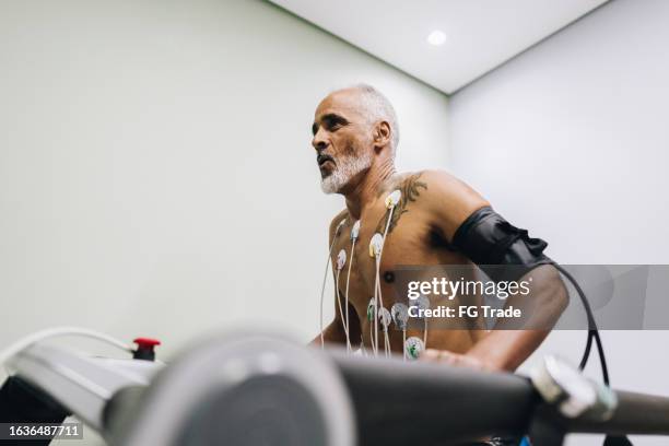 älterer patient macht kardiopulmonalen belastungstest in einer arztpraxis - belastungsprobe stock-fotos und bilder