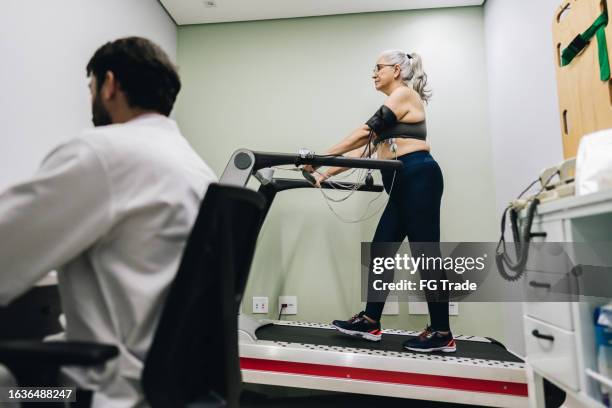 senior patient taking cardiopulmonary stress test on a doctor's office - stress test stock pictures, royalty-free photos & images