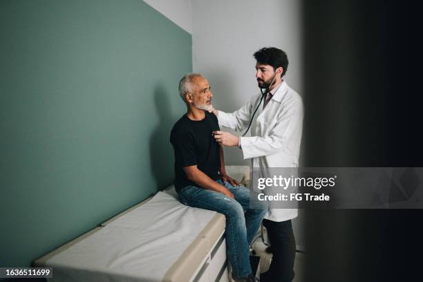 doctor examining a patient on a hospital - real human heart stock pictures, royalty-free photos & images