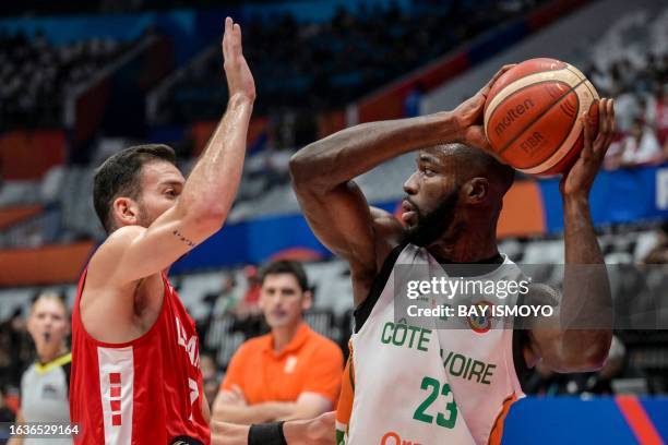 Ivory Coast's Cedric Bah looks to pass the ball next to Lebanon's Karim Zeinoun during the FIBA Basketball World Cup group P match between Ivory...