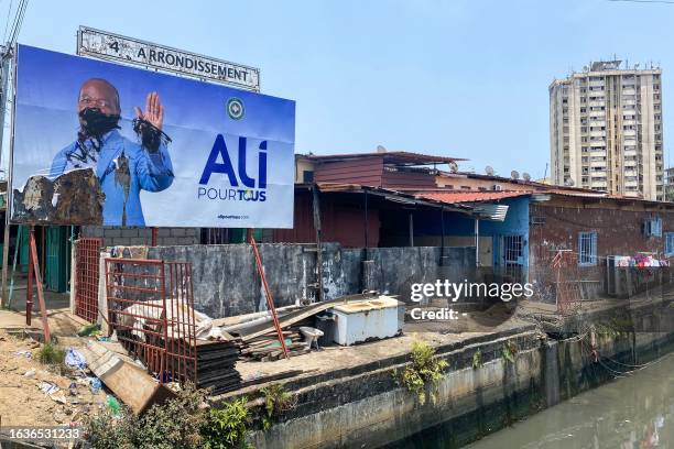 General view of a defaced campaign billboard of ousted Gabon President Ali Bongo Ondimba in Libreville on August 31, 2023. People in the central...